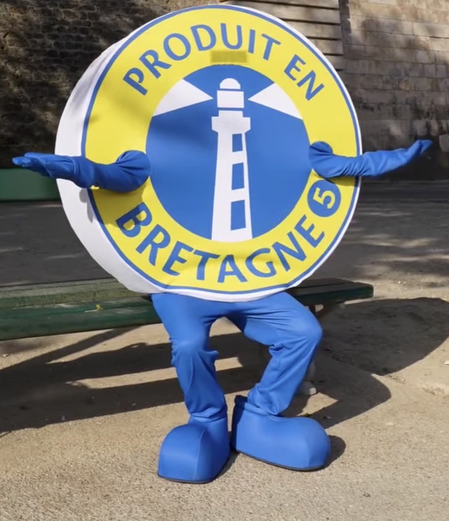 La mascotte Produit en Bretagne pose à Paris, bras ouverts